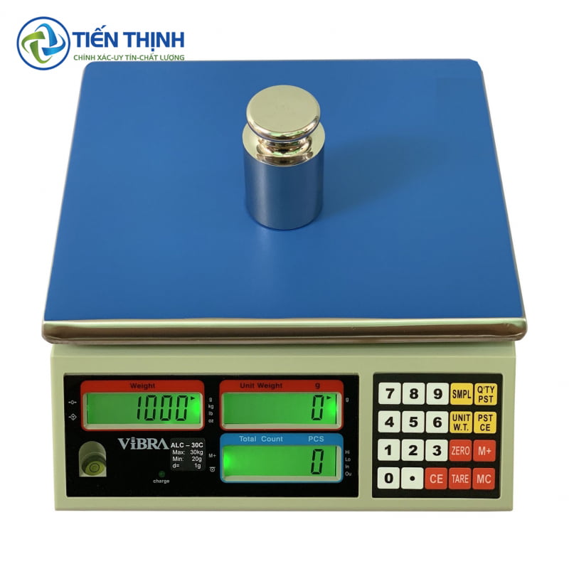 Cân điện tử kỹ thuật số với quả cân chuẩn, hiển thị số rõ ràng.