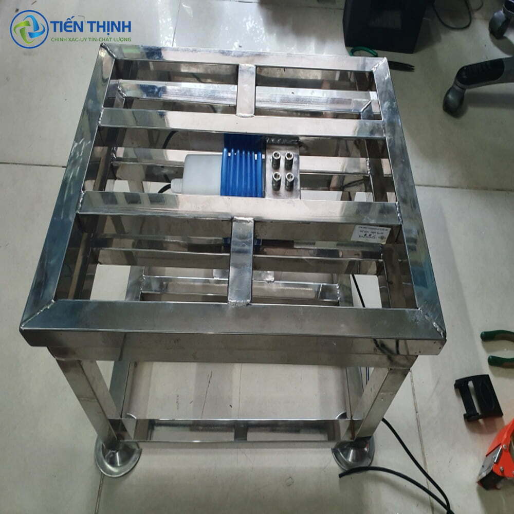 Khung máy làm bằng inox, có bánh xe, dùng trong công nghiệp.