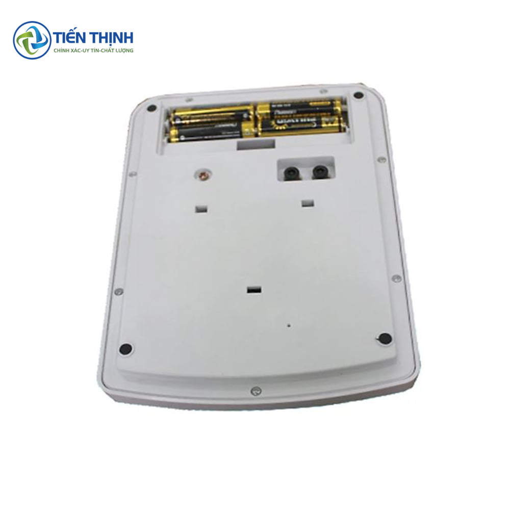 Mặt sau cân điện tử trắng, khoang chứa pin mở, pin AA bên trong.