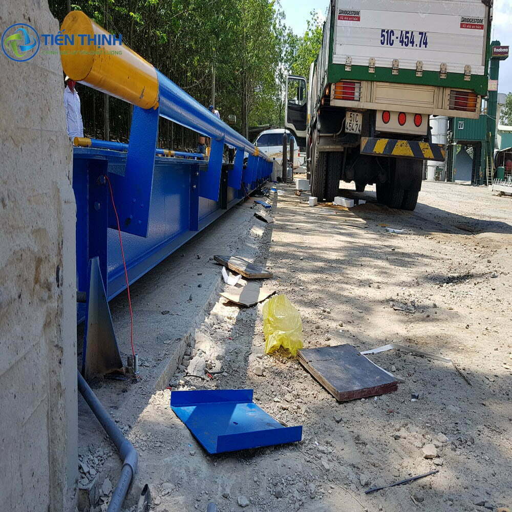 Máy vận chuyển xi măng màu xanh vàng và xe tải trên đường.