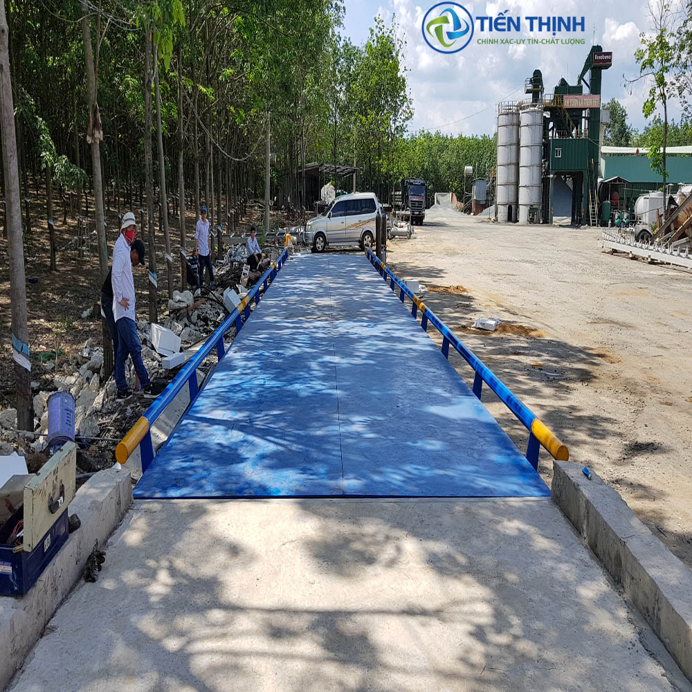 Cân điện tử dài, lớn dùng trong công nghiệp, có người kiểm tra.