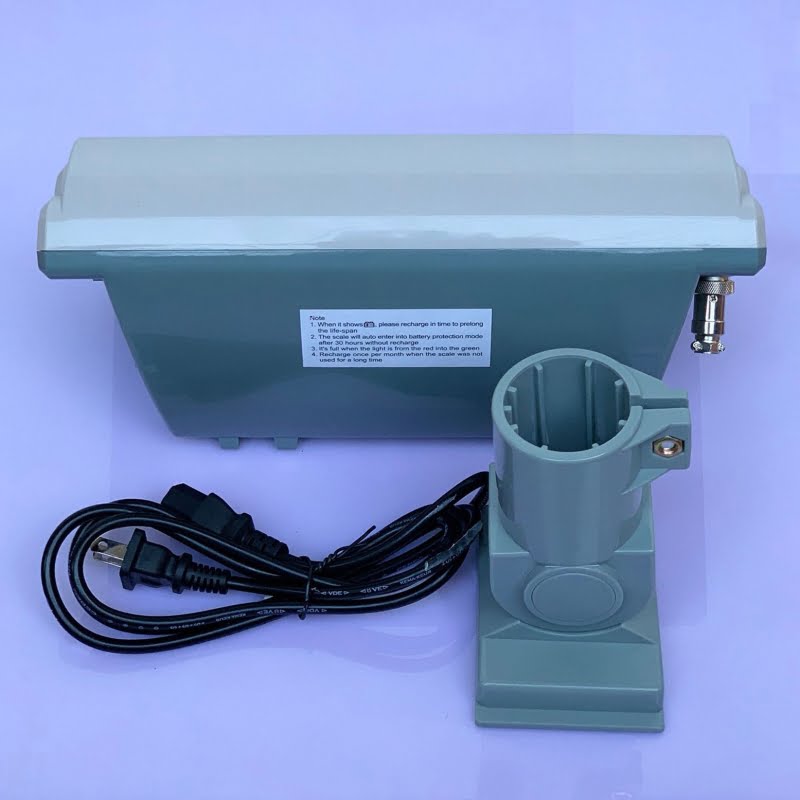 Thiết bị điện tử màu xanh lục với dây nguồn và giá đỡ.