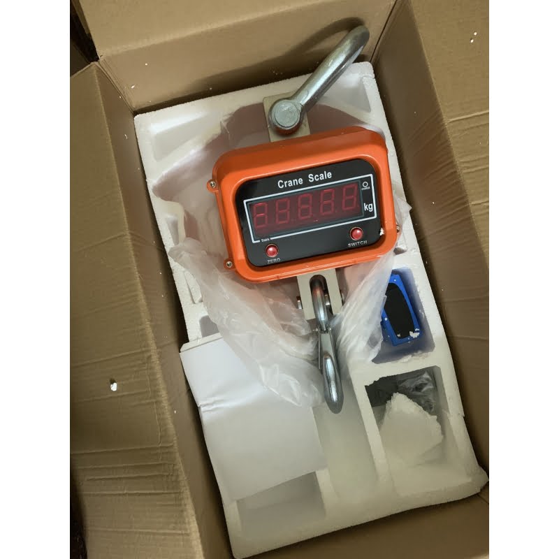 Cân treo điện tử màu cam, màn hình số hiển thị rõ ràng.