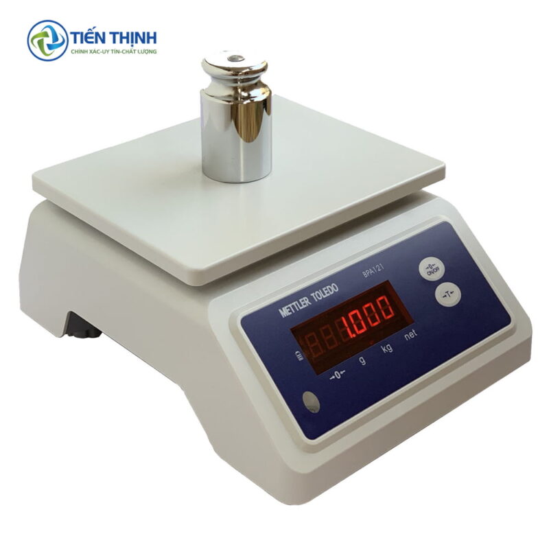 Cân điện tử Mettler Toledo màu trắng với quả cân tròn bằng kim loại.