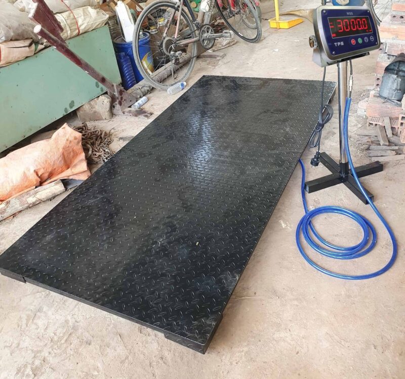 Cân điện tử cỡ lớn dùng trong công nghiệp, nền đen sần.