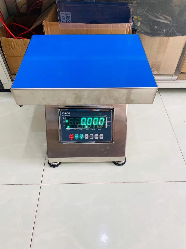 Cân điện tử công nghiệp màu bạc, mặt bàn cân màu xanh dương.