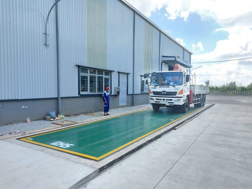 Xe tải đang cân tại khu vực nhà xưởng công nghiệp rộng lớn.