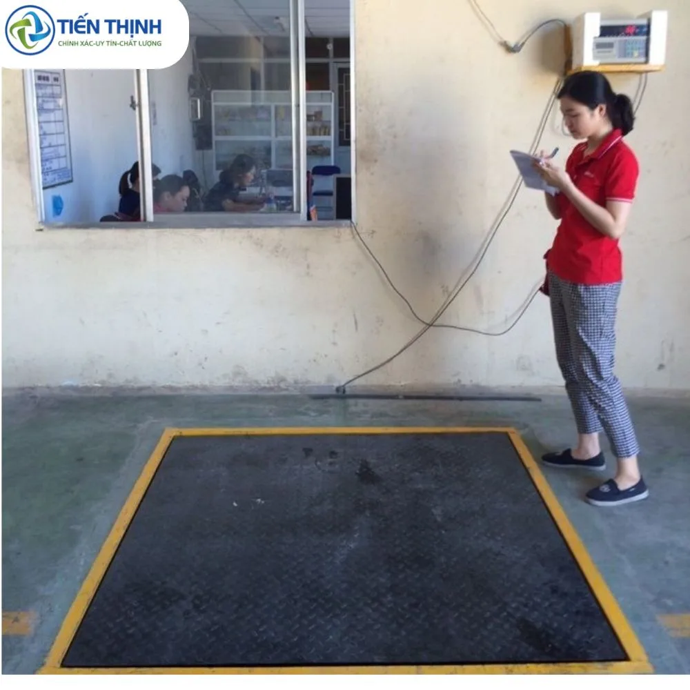 Một nhân viên đang ghi chép dữ liệu bên cạnh cân ô tô công nghiệp.