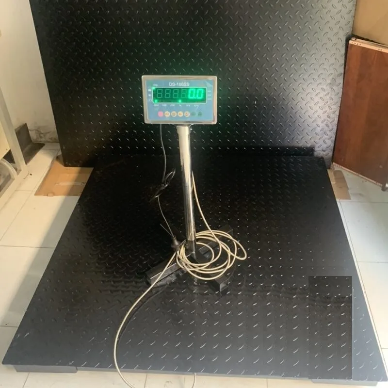 Cân điện tử công nghiệp với mặt cân đen và màn hình hiển thị số.