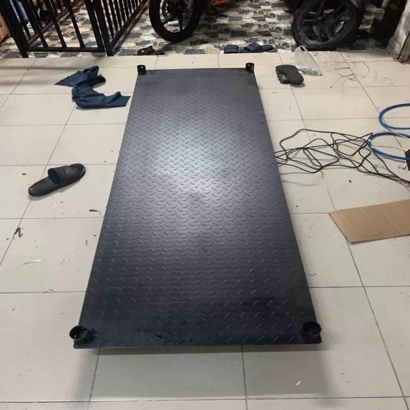 Tấm cao su chống trượt hình chữ nhật màu đen nằm trên sàn gạch.