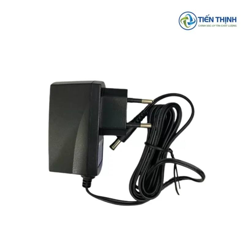 Bộ sạc điện tử màu đen, đầu cắm tròn, dây đen cuộn tròn.