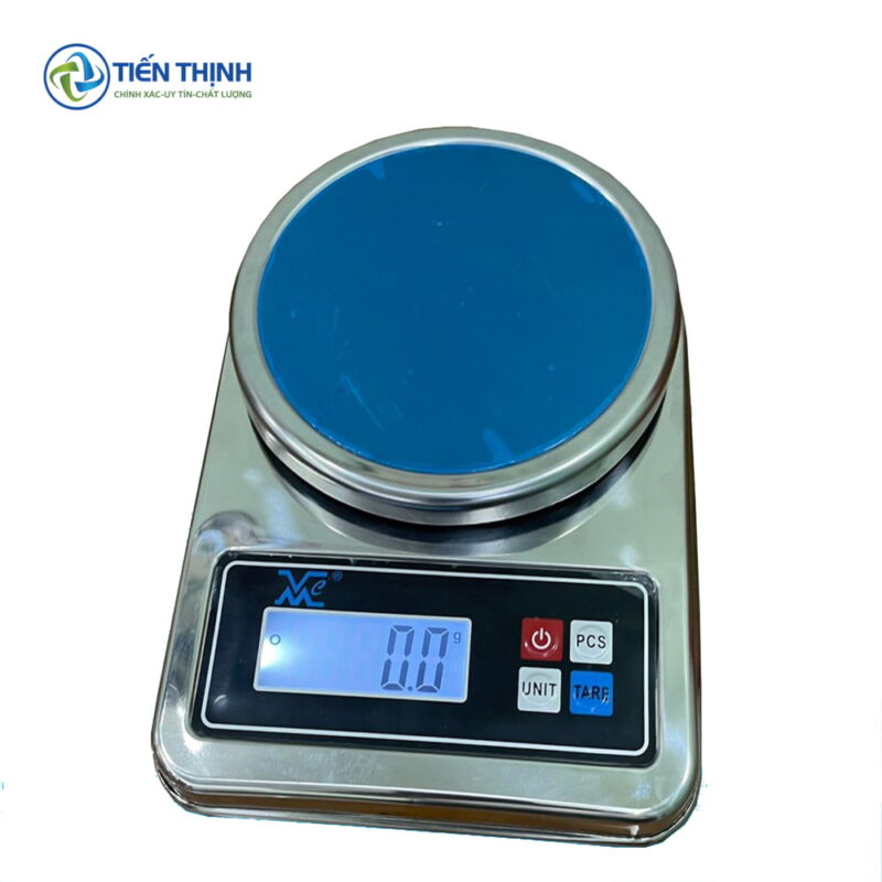 Cân điện tử nhỏ gọn, mặt cân tròn màu xanh dương, hiển thị số.