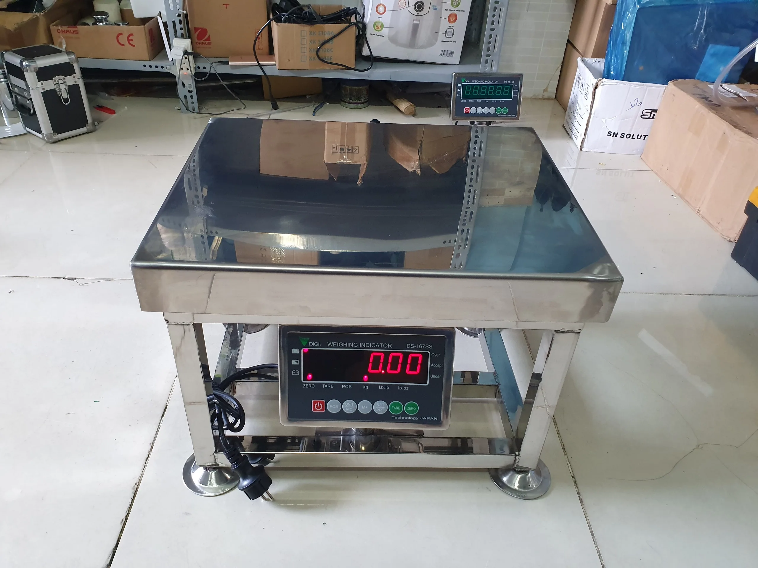 Cân điện tử mặt inox vuông vức, màn hình số hiển thị rõ ràng.