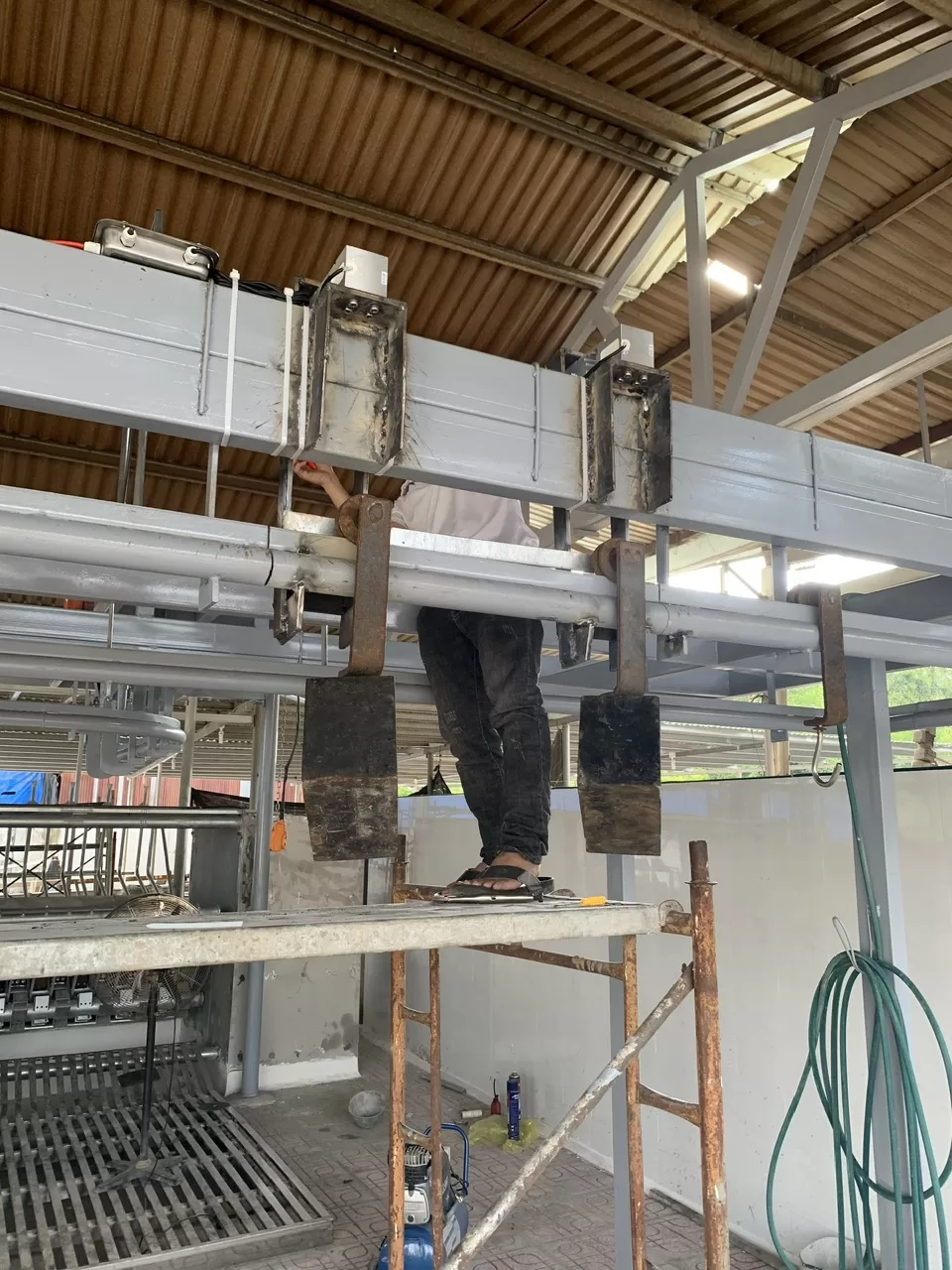 Người đàn ông đang sửa chữa hệ thống điện trên cao.